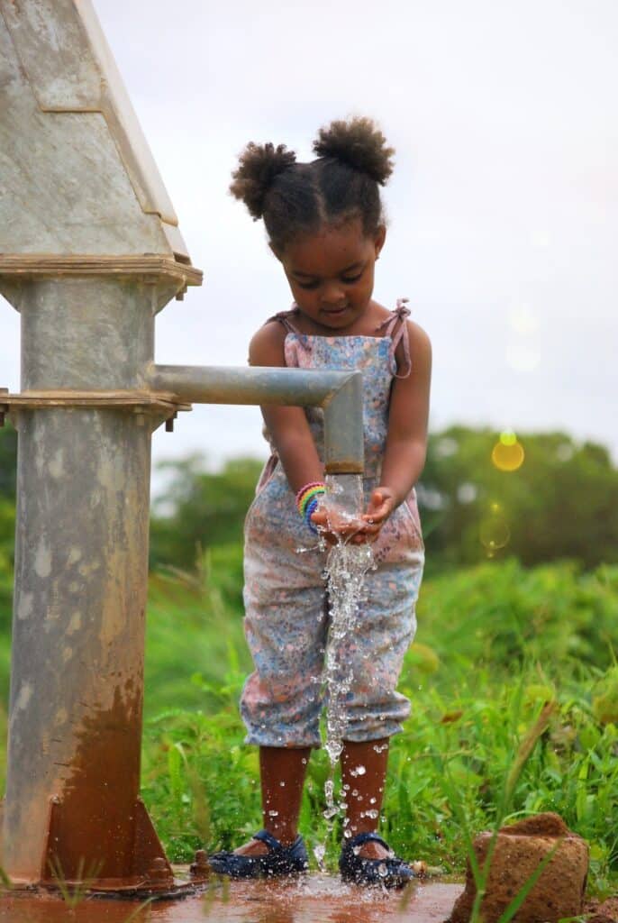 Girl washing her hands at a water well in burkina Faso, africa